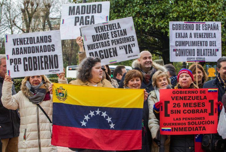 Cerca de 40 personas se han concentrado hoy en la plaza de la Escandalera de Oviedo para exigir al presidente de Venezuela, Nicolás Maduro, el pago de las pensiones a 1.500 pensionistas y jubilados venezolanos residentes en Asturias que llevan 26 meses si