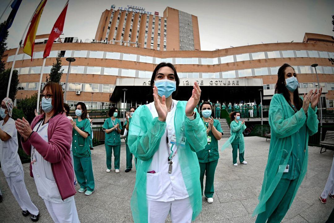 Personal sanitario del hospital 12 de Octubre de Madrid agradecen los aplausos de los vecinos y los miembros de la Policía Municipal por su labor en la lucha contra el coronavirus, este lunes en la sexta semana del estado de alarma por la pandemia del COVID-19. EFE- Fernando Villar