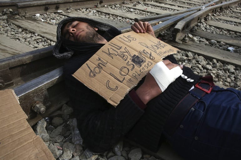 Un refugiado protesta en contra del cierre de las fronteras en las vías del tren del campamento provisional de Idomeni, en la frontera entre Grecia y Macedonia (Grecia)