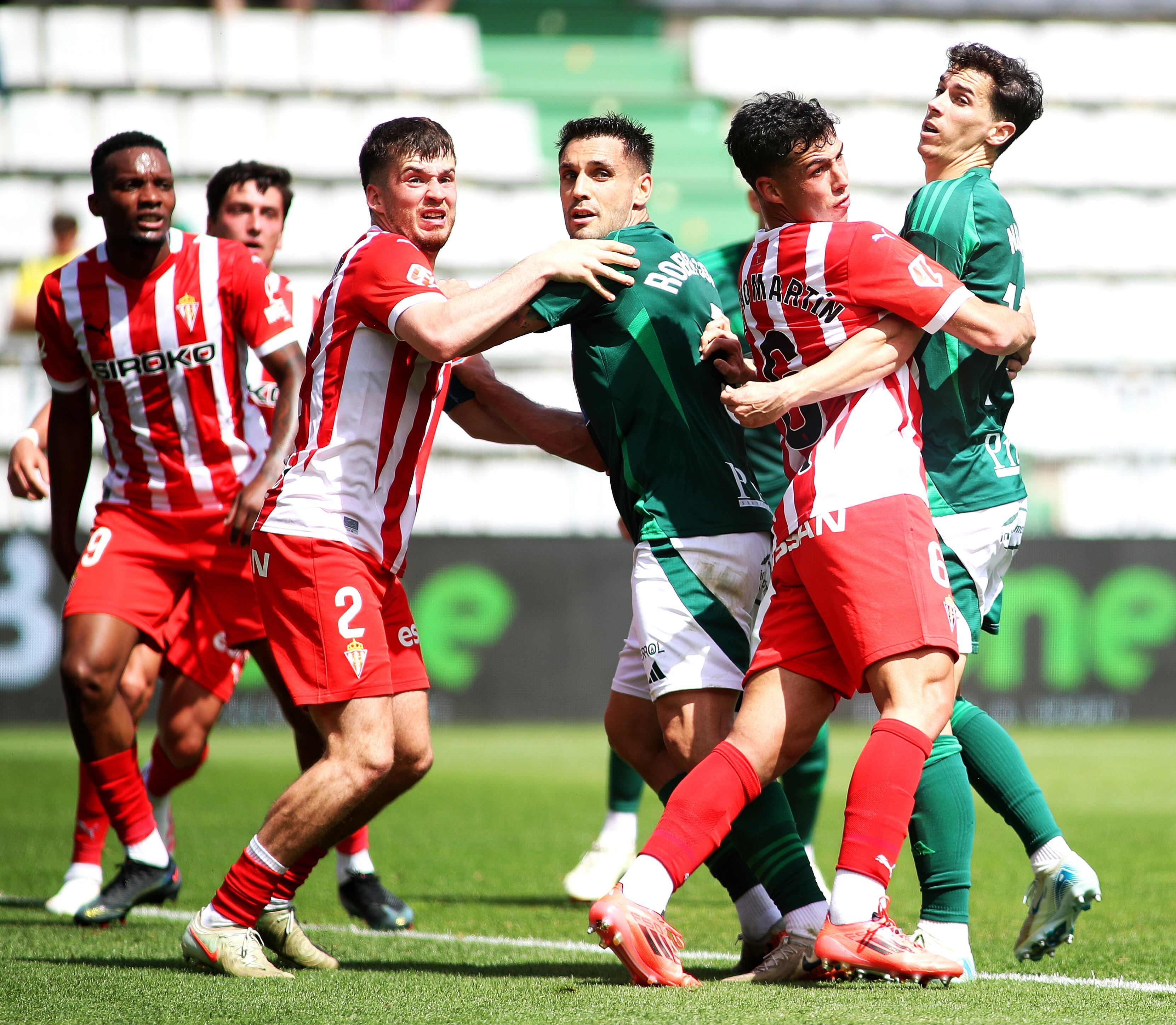Rober Correa y Nacho pugnan con rivales durante el Racing-Sporting en A Malata (foto: Mariño / Cadena SER)