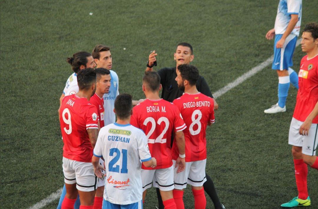 Los jugadores herculanos hablan con el colegiado, ante Prat