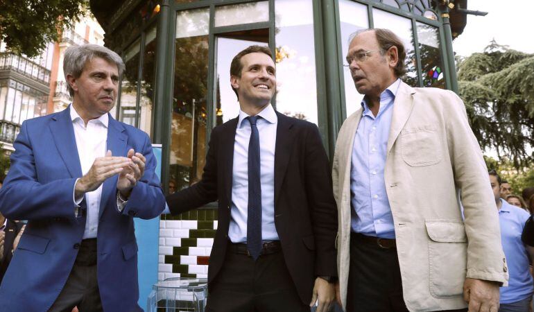 El candidato a liderar al PP, Pablo Casado (c), junto al presidente de la Comunidad de Madrid, Ángel Garrido (i), y el presidente del Senado, Pío García-Escudero, durante el acto de fin de campaña que ha celebrado hoy en el paseo de Recoletos, en Madrid.