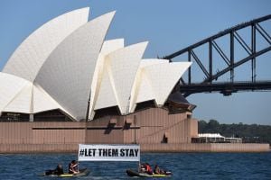 SYD. Sydney (Australia), 13/02/2016.- A picture made available 26 June 2016 shows a group of demonstrators holding a protest sign referring to group of 267 asylum seekers being returned to the offshore detention center on Nauru, at the harbour in Sydney, 