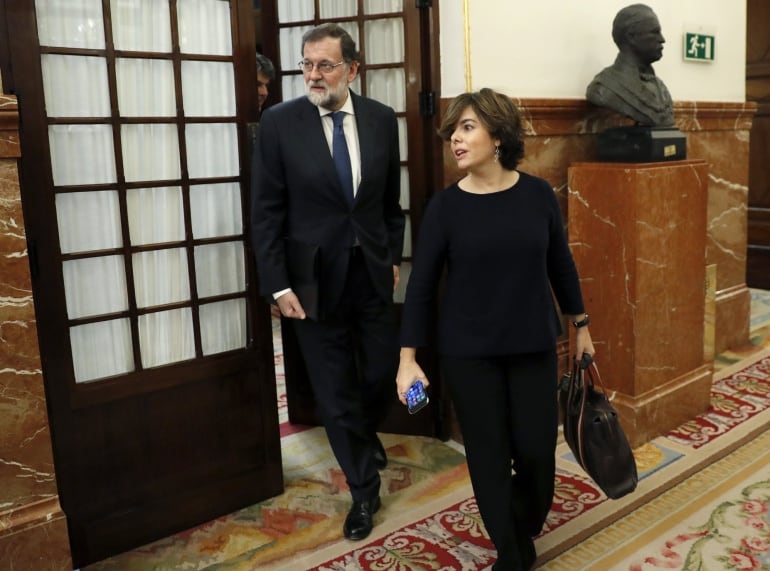 El presidente del Gobierno, Mariano Rajoy,iz., y la vicepresidenta, Soraya Saénz de Santamaría, abandonan el hemiciclo del Congreso