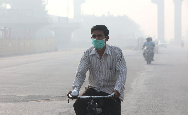 Un hombre utiliza mascarilla mientras circula en bicicleta por Nueva Delhi (India)  a causa de la contaminación provocada por el tráfico y la quema de rastrojos. 