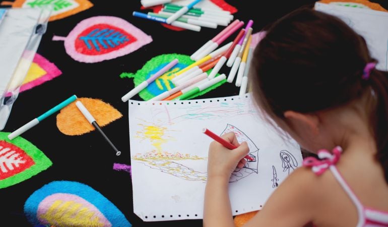 Una niña dibuja en el colegio