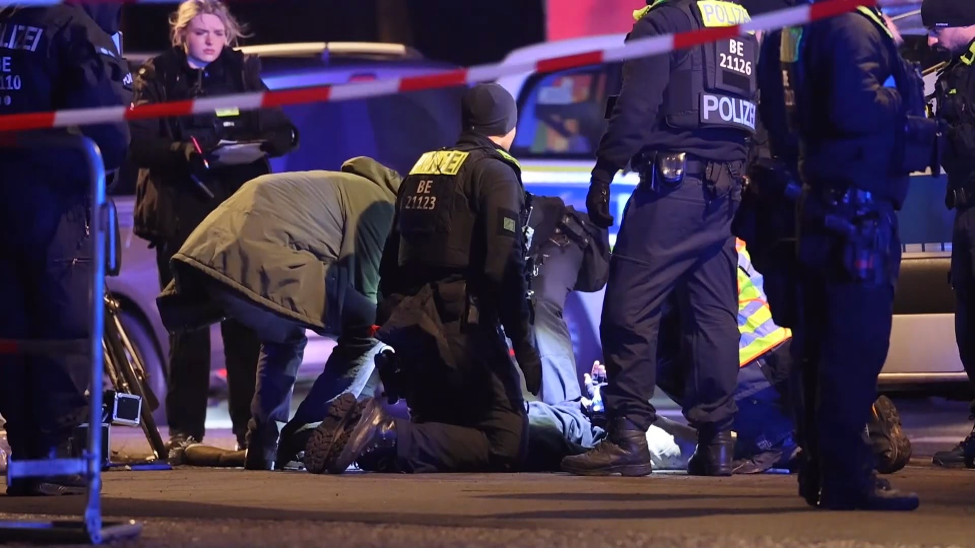 Agentes de policía asistiendo a un hombre español apuñalado con un cuchillo junto al monumento a las víctimas del Holocausto este viernes, en Berlín (Alemania).