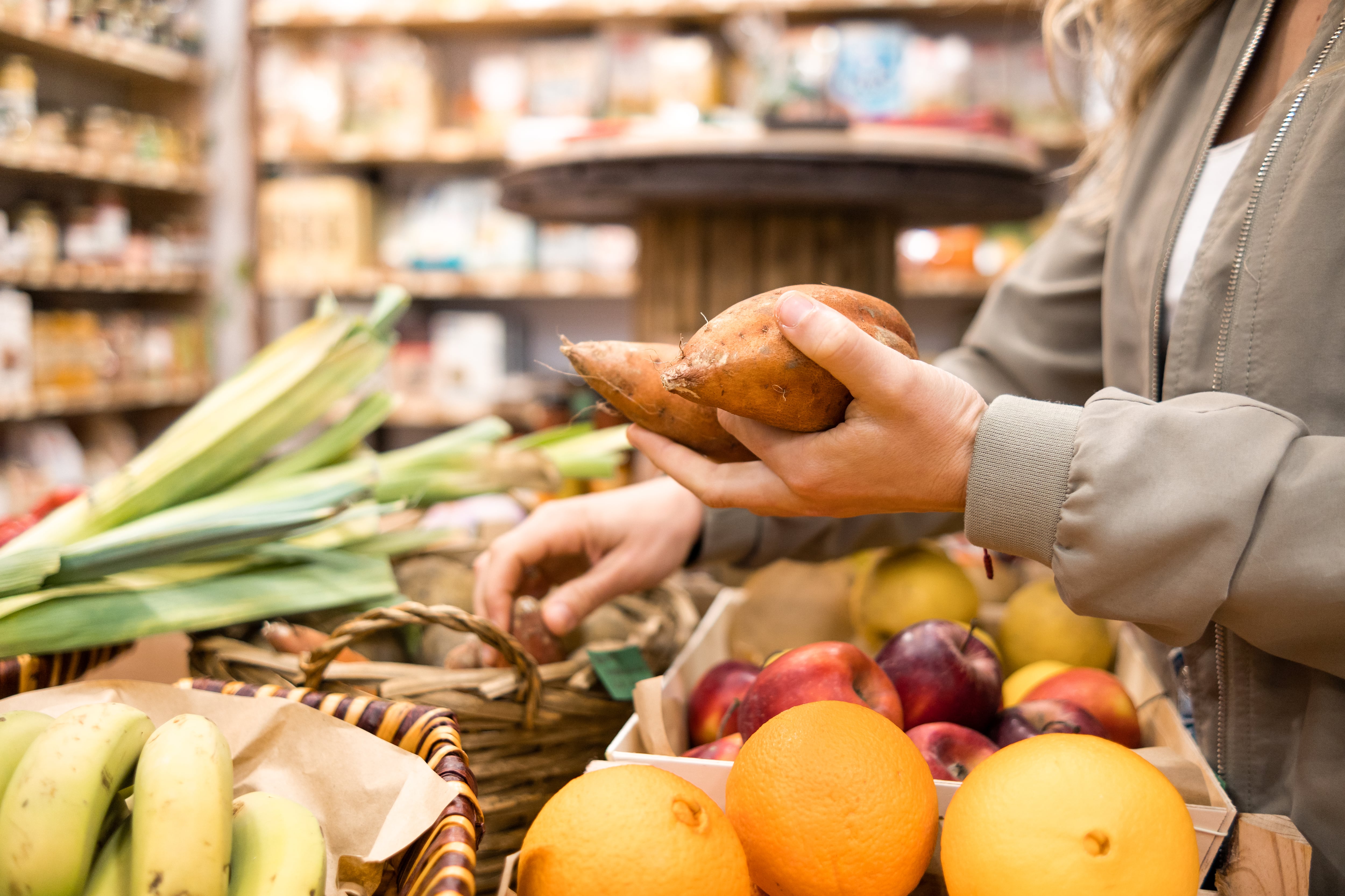 Una mujer compra verduras en un supermercado.