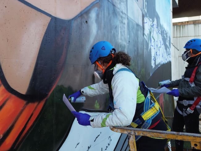 Cristina Domínguez (Crisdose) y Ángel Caballero (Xolaka) durante el proceso de creación del mural.