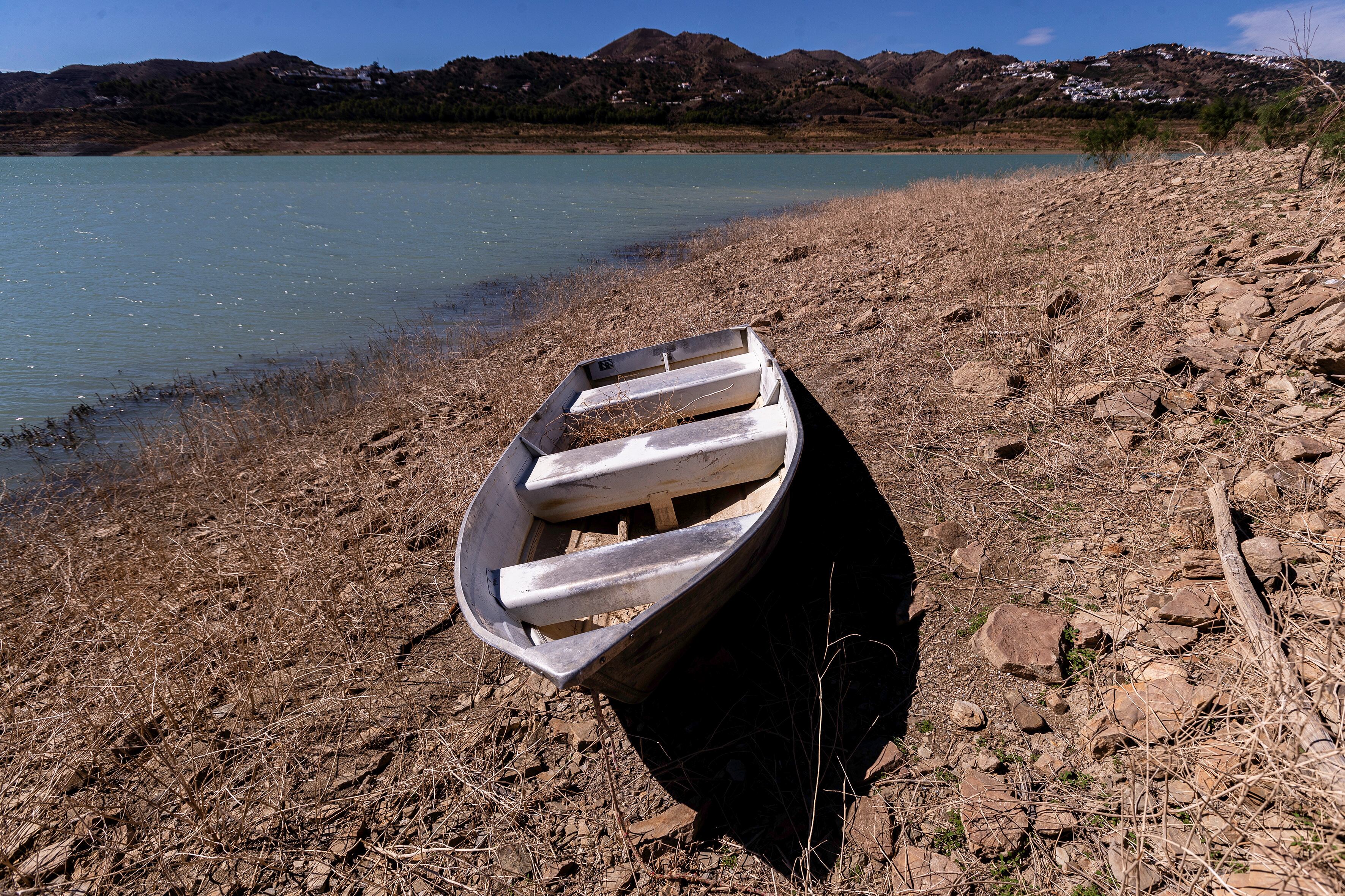 LA VIÑUELA (MÁLAGA), 27/09/2024.- Una barca sobre la orilla seca por la escasez de agua en el pantano de La Viñuela en Málaga. Andalucía ha perdido este verano una cuarta parte de sus reservas de agua en los embalses de la comunidad, que iniciaron la época estival al 40,6 % de capacidad y la han terminado al 29,4 %, lo que supone 1.268 hm3 menos. EFE/ Jorge Zapata
