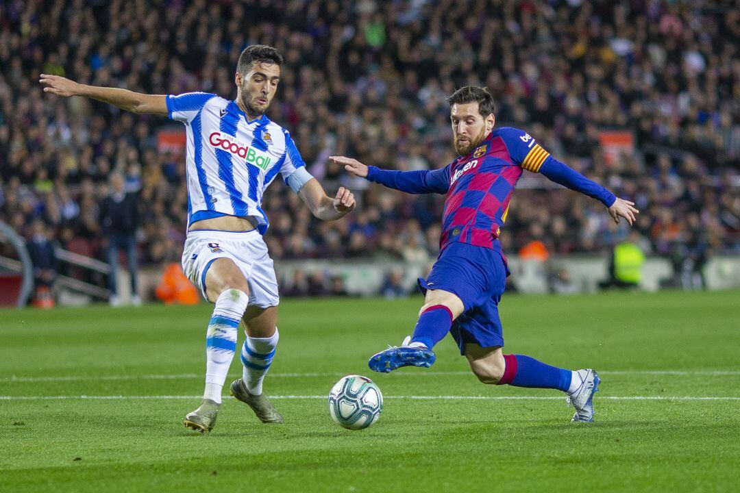 Mikel Merino y Leo Messi disputando un balón