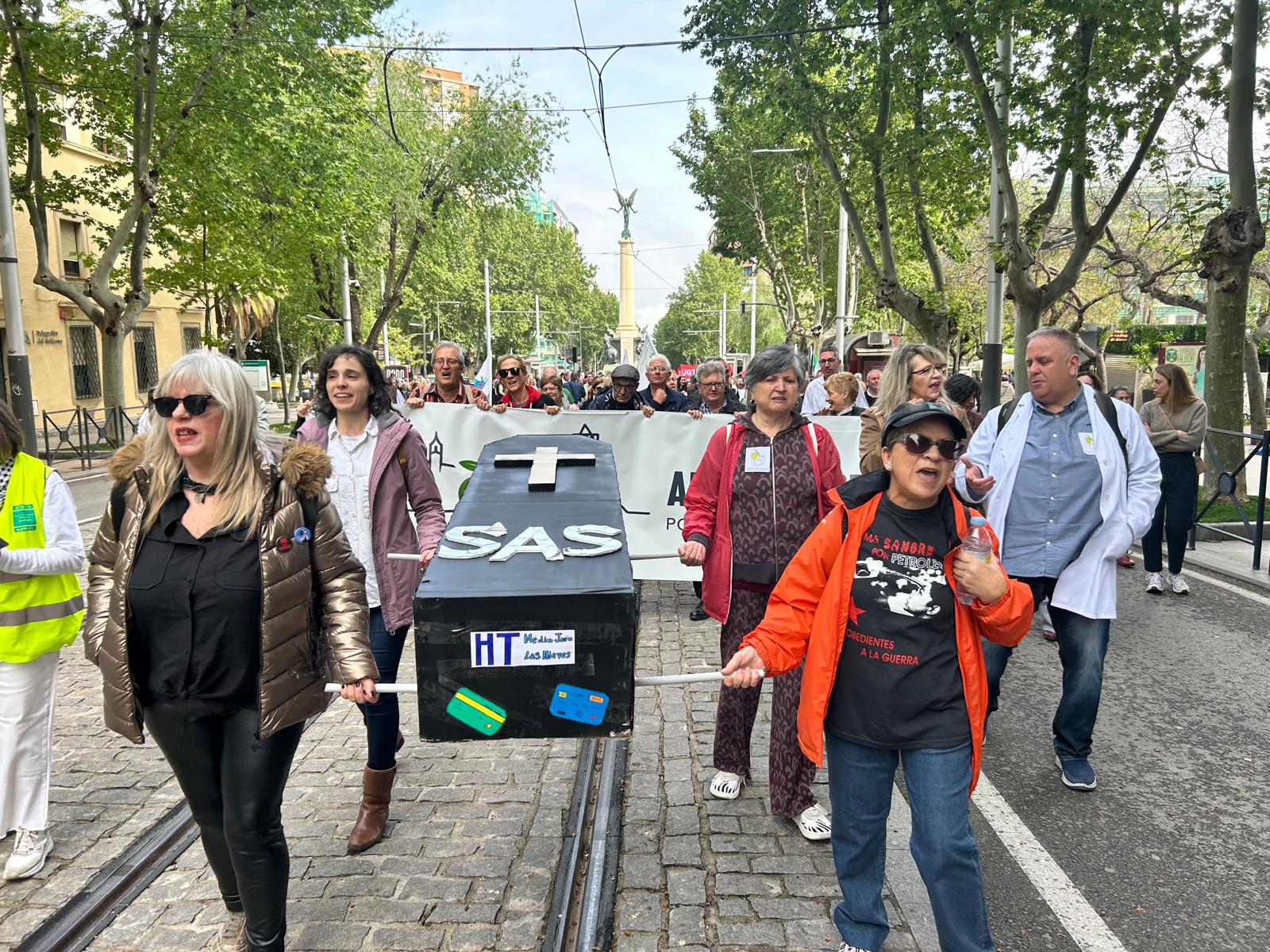 Varias asistentes portan un ataúd simulando el fallecimiento del SAS debido a los acuerdos con las aseguradoras privadas.