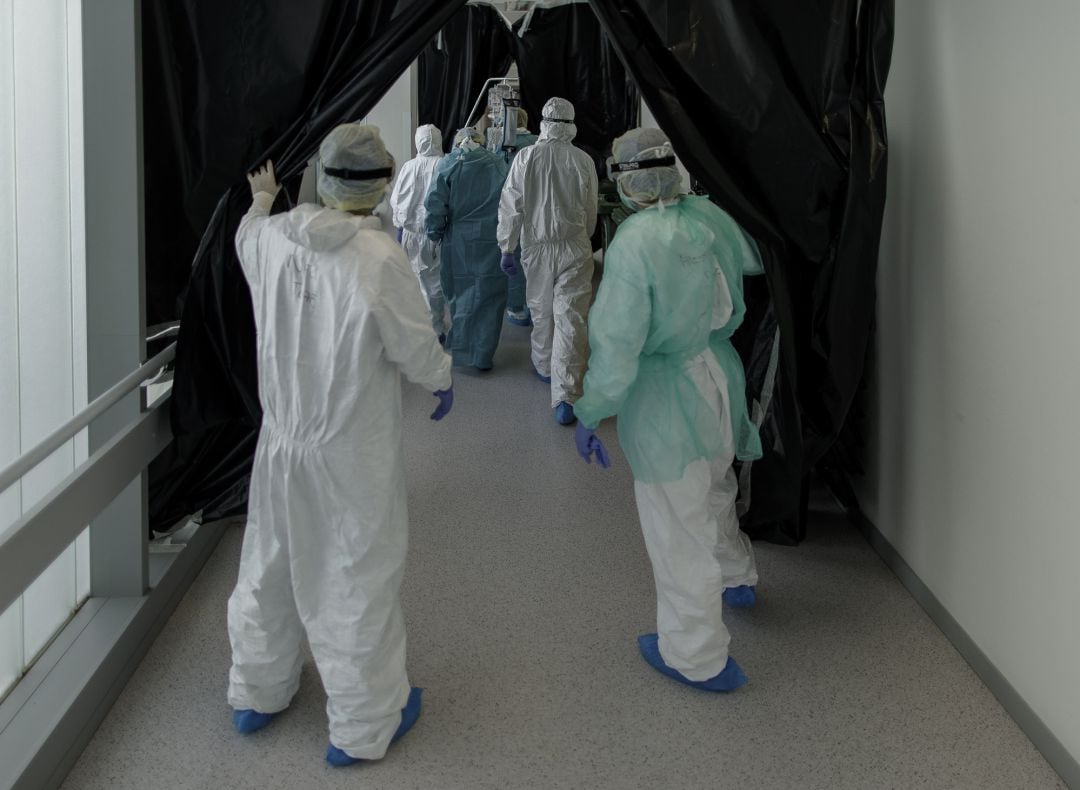 Personal sanitario totalmente protegido traslada a un paciente ingresado en la Unidad de Cuidados Intensivos del Hospital Infanta Sofía en San Sebastián de los Reyes. 