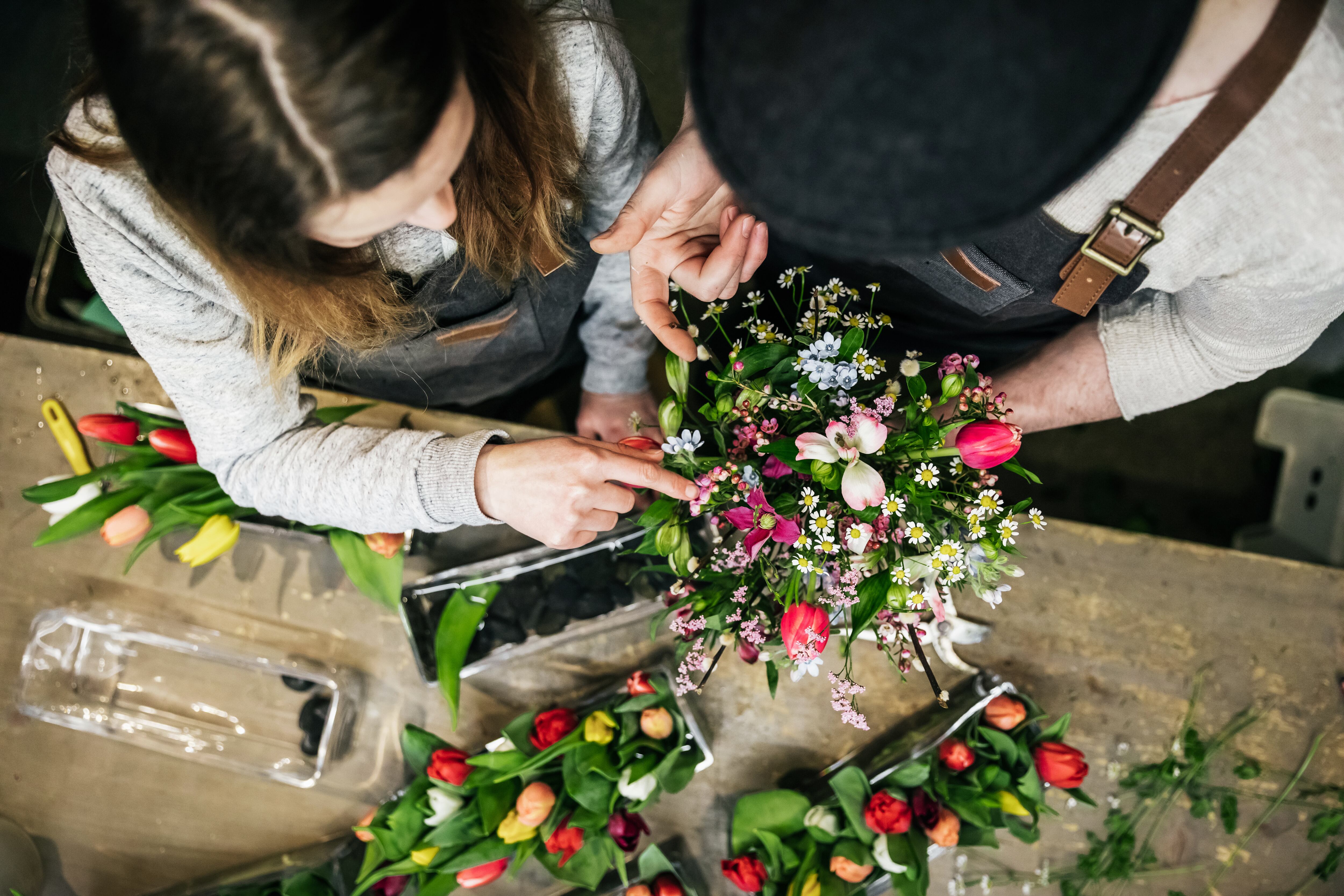 Dos floristas preparando un centro de flores, en una imagen de archivo