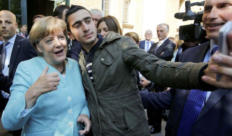 El refugiado sirio Anas Modamani se saca un selfi con la canciller alemana, Angela Merkel, junto a un centro de refugiados del distrito berlinés de Spandau el 10 de septiembre de 2015.