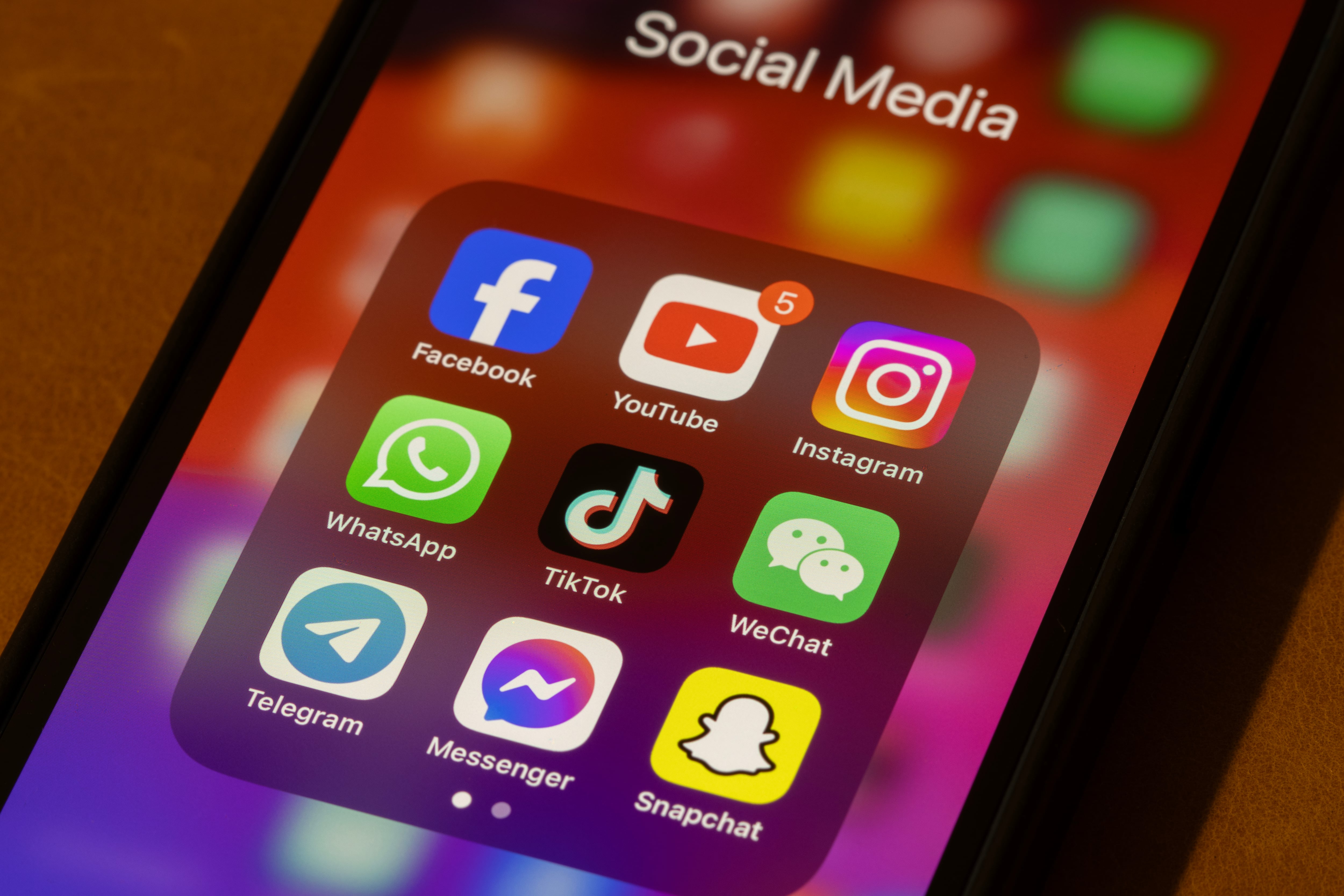 Portland, OR, USA - Nov 11, 2024: Some of the most popular social media apps by number of monthly active users, including Facebook, YouTube, Instagram, WhatsApp, TikTok, WeChat, Telegram, Messenger, and Snapchat, are seen on an iPhone.