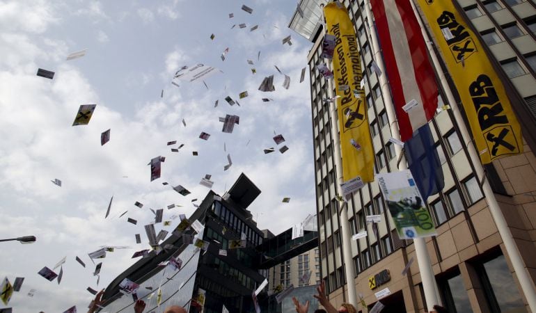 Varios manifestantes lanzan al aire billetes falsos durante una protesta contra el blanqueo de dinero en Viena.