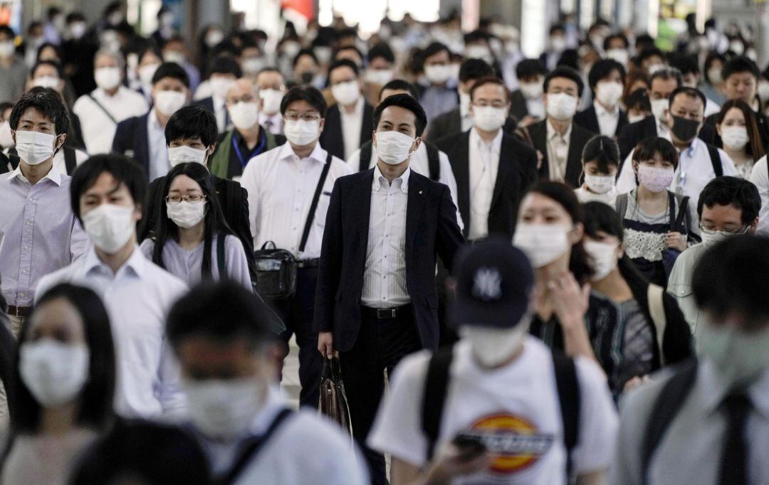 Decenas de japoneses se dirigen al metro en la estación de Shinagawa, en Tokio, para ir a trabajar durante el Estado de emergencia.