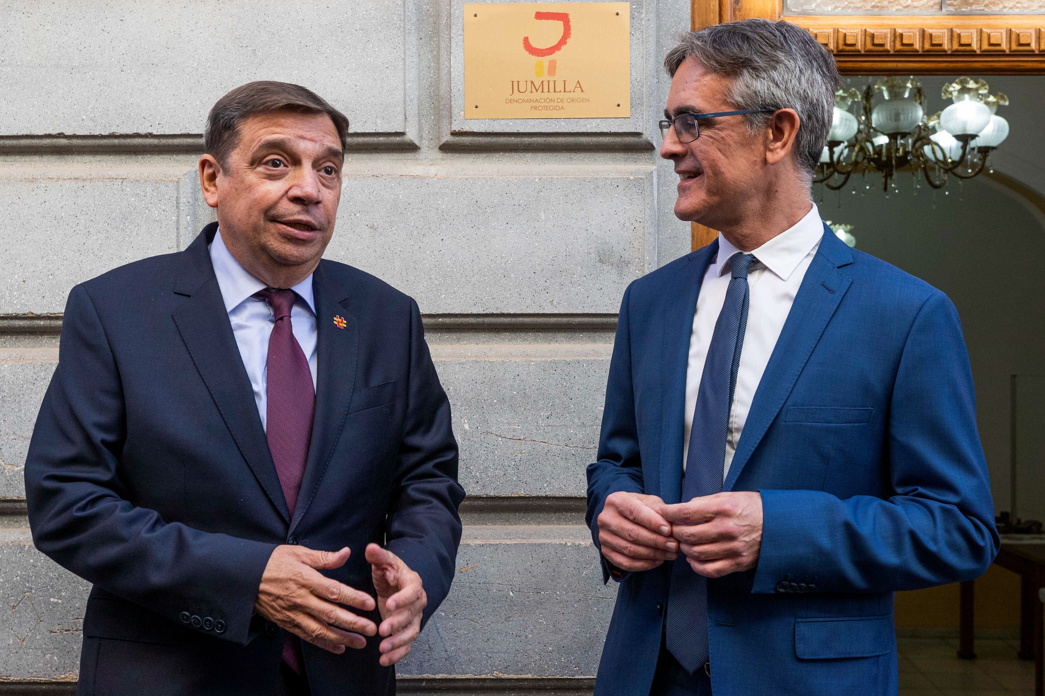 El ministro de Agricultura, Pesca y Alimentación, Luis Planas (i), acompañado por el presidente del Consejo Regulador de la Denominación de Origen Protegida de Jumilla Silvano García Abellán (d), a su llegada a la sede del Consejo Regulador DOP Jumilla, este lunes con motivo del viaje oficial que está realizando a Jumilla