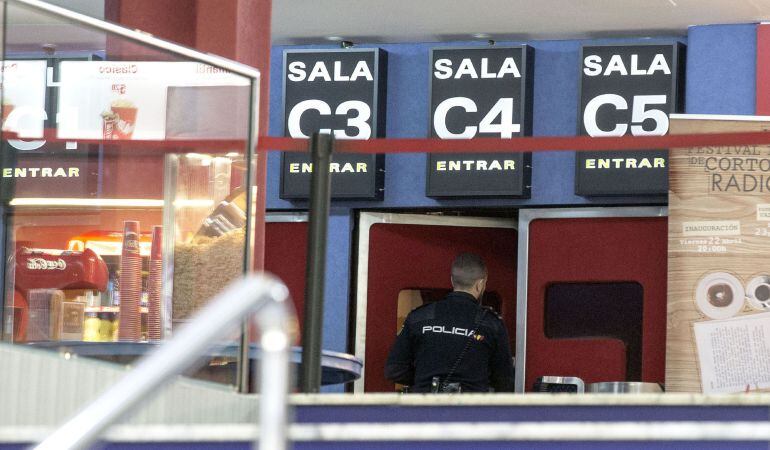 Un agente de policía entra en una de las salas del céntrico cine de Valencia donde ha aparecido el cuerpo sin vida de una mujer