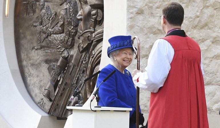 La reina Isabel II conversa con un clérigo.