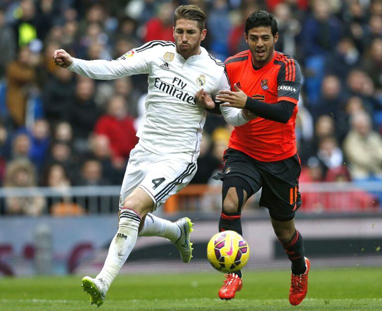 GRA237. MADRID, 31/01/2015.- El defensa del Real Madrid Sergio Ramos (i) disputa un balón con el delantero mexicano de la Real Sociedad Carlos Vela (d), durante el partido de la vigésimo primera jornada de Liga de Primera División disputado esta tarde en el estadio Santiago Bernabéu. EFE/Juan Carlos Hidalgo