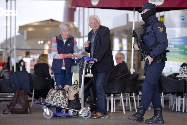 GRA249. MÁLAGA 09/01/2015.- Un agente del Cuerpo Nacional de Policía en labores de vigilancia en una de las terminales del aeropuerto de Málaga, dentro de las medidas derivadas de la elevación por parte del Ministerio del Interior del nivel actual de aler