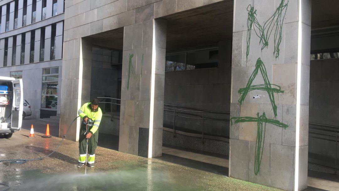 Un operari neteja una pintada antiMAT als jutjats de Girona