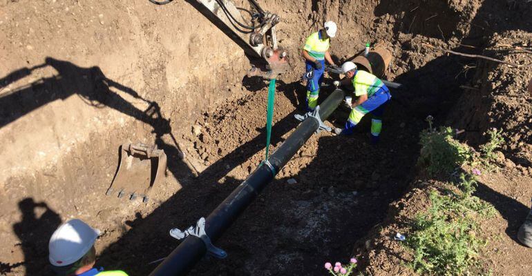 Varios obreros trabajan en una canalización de agua.