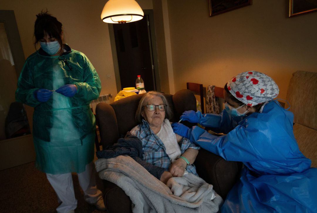 Una enfermera administra la primera dosis de la vacuna BioNTech Pfizer a una paciente mayor de 80 años