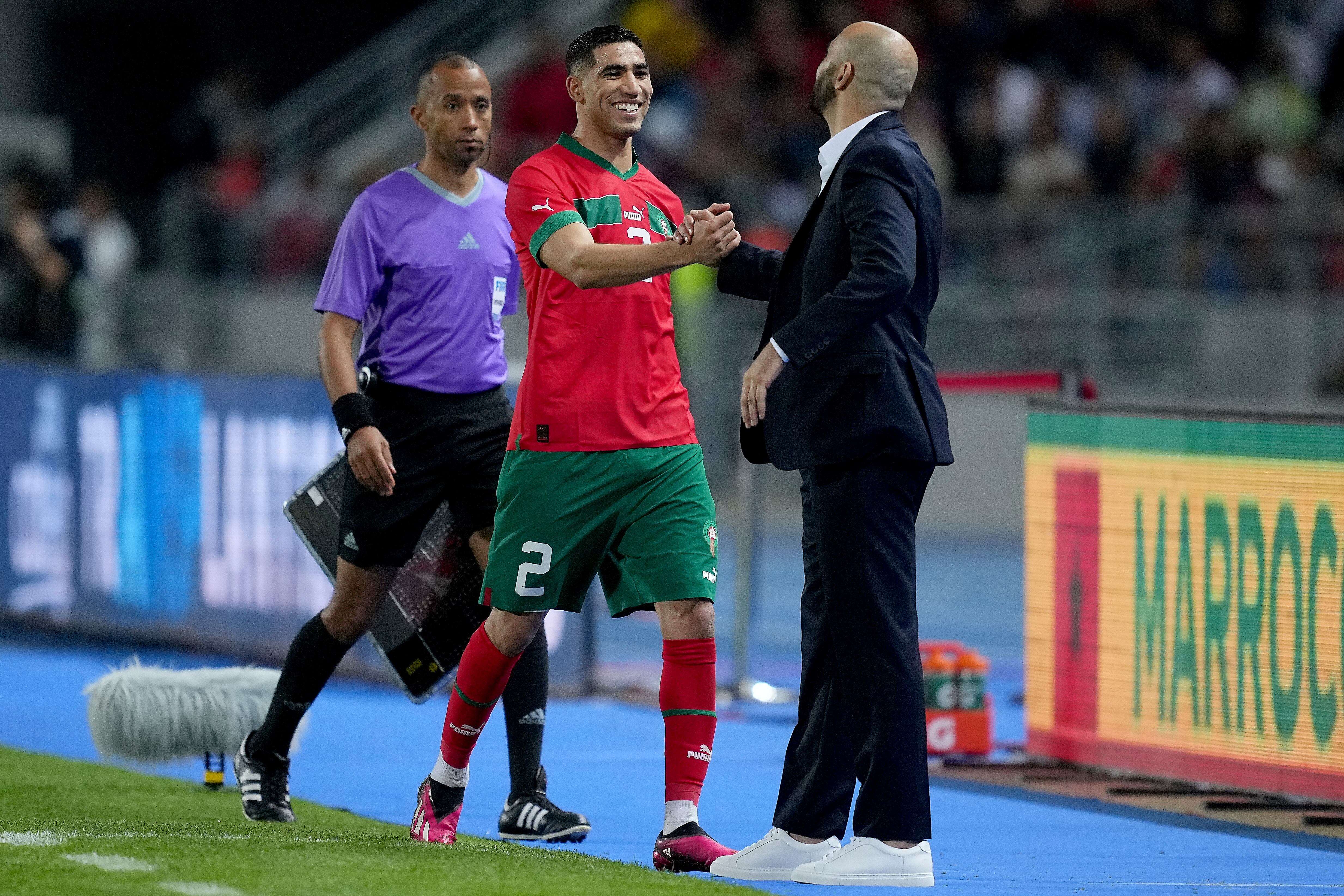 Achraf Hakimi y Walid Regragui se saludan de forma amistosa
