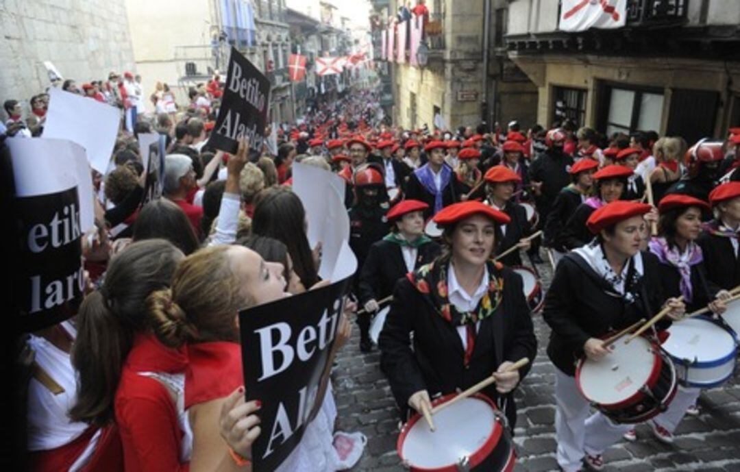 La compañía Jaizkibel desfila ante carteles y plásticos en la calle Mayor de Hondarribia. 