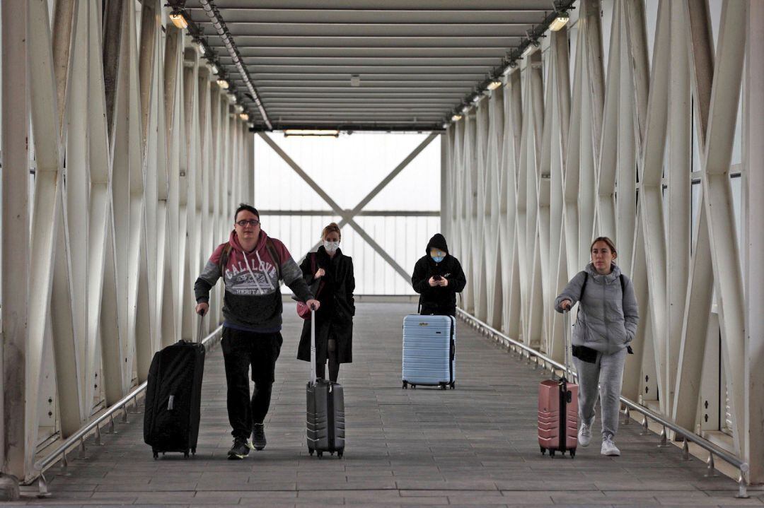 Varios viajeros en el Aeropuerto de El Prat (Barcelona), este miércoles durante la cuarta jornada en estado de alarma por la pandemia de coronavirus.