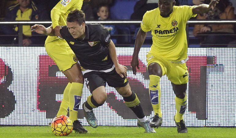 GRA225. VILLARREAL (CASTELLÓN), 31/10/2015.- El centrocampista del Sevilla Vitolo (c) entre el centrocampista mexicano Jonathan dos Santos (i) y el defensa marfileño Eric Bailly (d), del Villarreal, durante el partido de la décima jornada de la Liga de Primera División que se juega hoy en el estadio de El Madrigal. EFE/Domenech Castelló