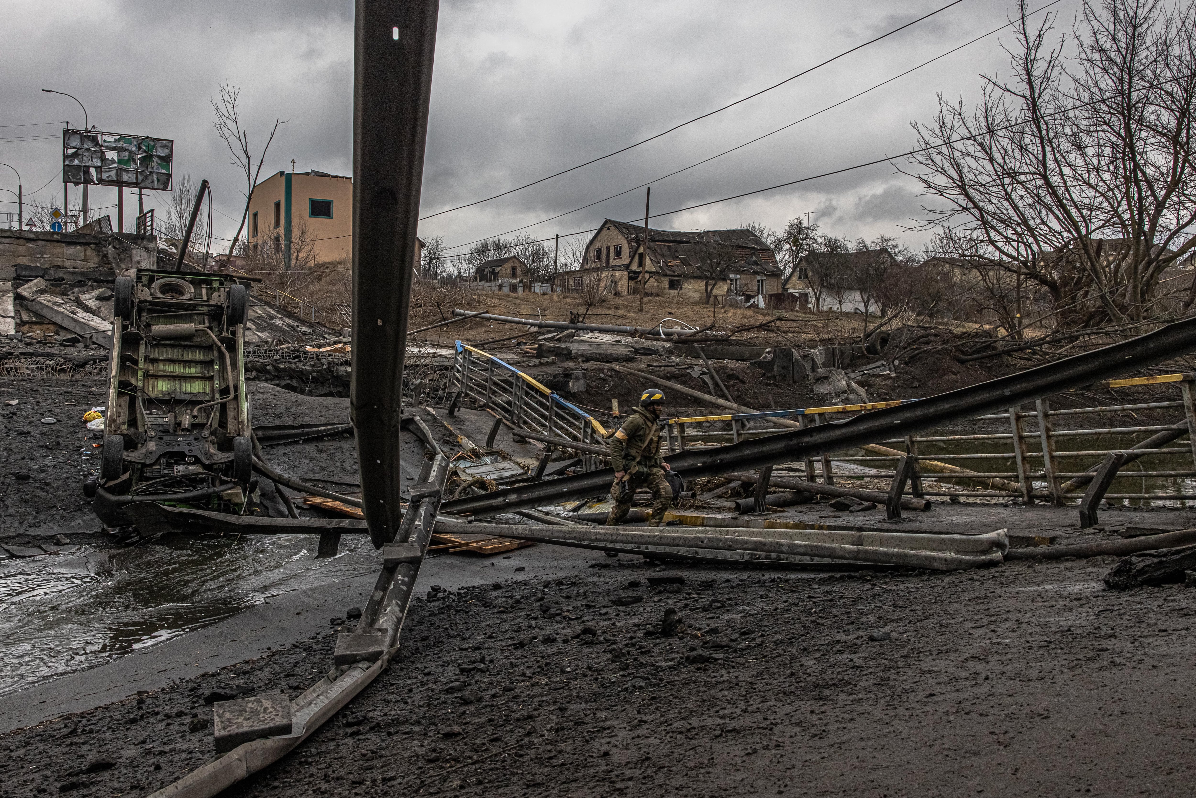 Un militar ucraniano atravesando un puente destruido en la capital de Ucrania, Kiev