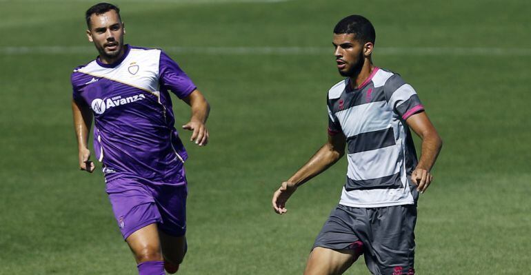 Abdel, defensa del Granada B, conduce el balón ante la presión del delantero del Real Jaén, Antonio López.