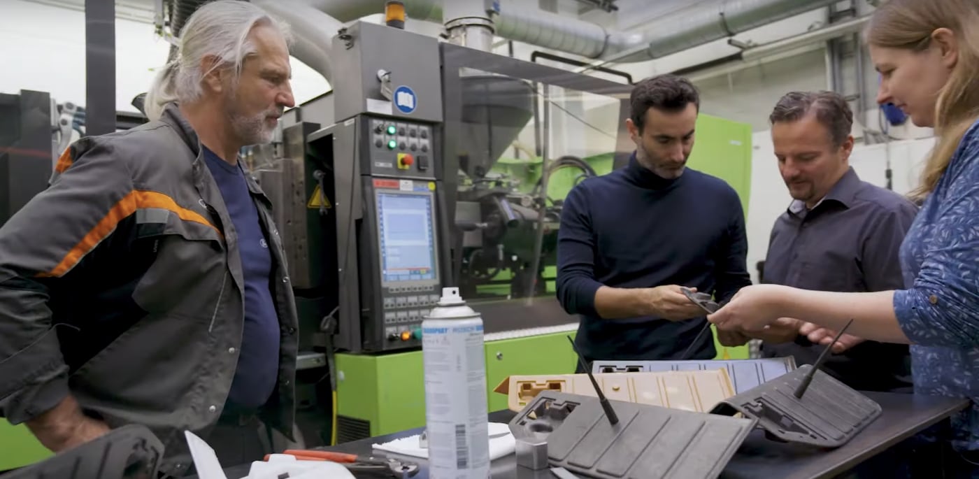 Profesionales de la marca Ford con piezas hechas con ramas y hojas de olivo en sus manos.