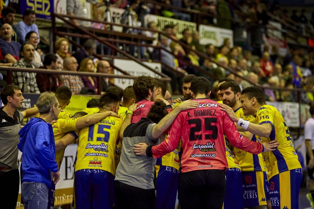 Los jugadores y cuerpo técnico hacen una piña durante el partido.