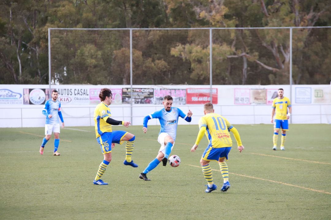 Carlos Calvo conduciendo la pelota ante dos contrarios