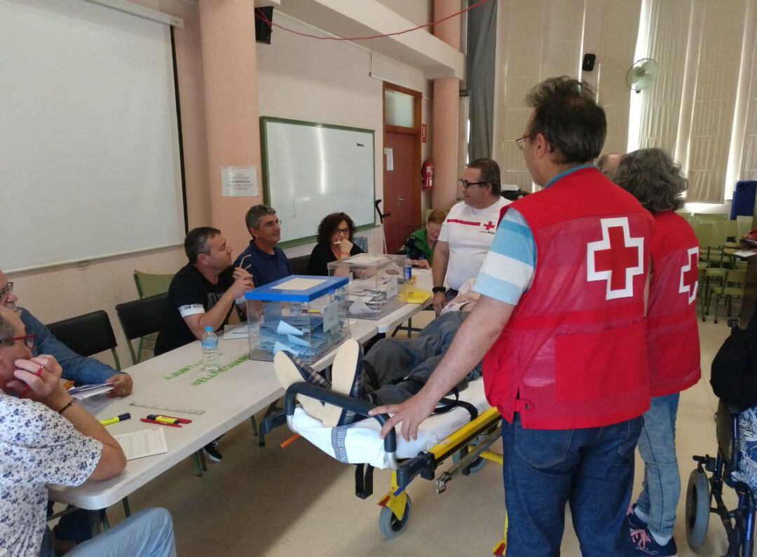 Voluntarios acompañan a personas con problemas de movilidad a depositar su voto en las pasadas elecciones en una imagen de archivo.