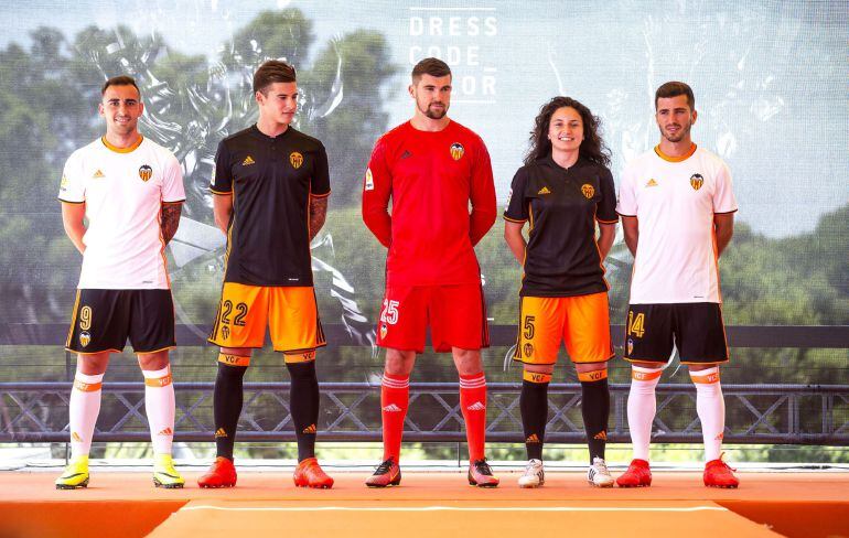 GRA244. VALENCIA, 08072016.- Los jugadores de la primera plantilla del Valencia CF, Paco Alcacer, Santi Mina, el portero Matthew Ryan y José Luis Gayá (izqda a dcha), y la jugaodra del Valencia femenino, Ivana, posan con las nuevas equipaciónes que lucirá