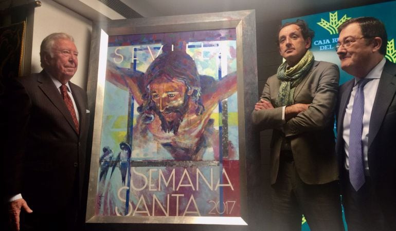 El pintor José Cerezal, a la derecha de su cartel de la Semana Santa, será el encargado de realizar el anuncio pictórico del Corpus Christi