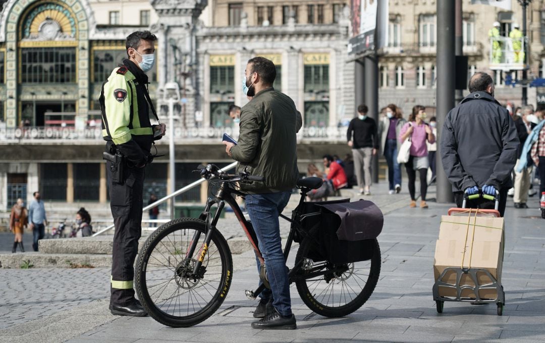 Un hombre habla con un agente un día después de la petición del Gobierno vasco de la declaración del estado de alarma.