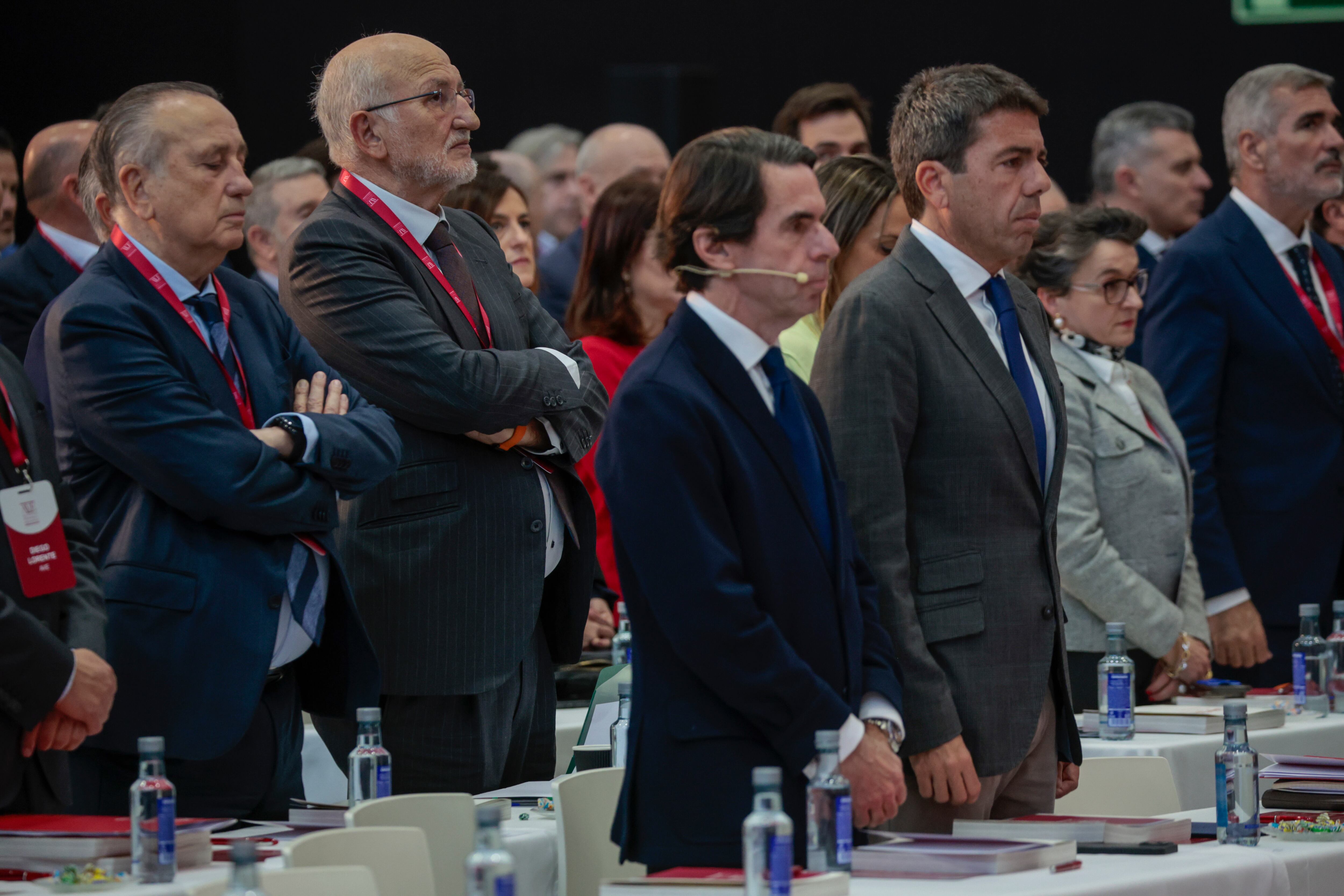 El expresidente del Gobierno José María Aznar, el president de la Generalitat, Carlos Mazón (d), el empresario, Juan Roig (2º i), y otros asistentes guardan un minuto de silencio por las victimas del incendio que el pasado jueves se cobró la vida de diez personas en un edificio de Campanar al inicio de la asamblea general de la Asociación Valenciana de Empresarios (AVE) que se celebra este miércoles.