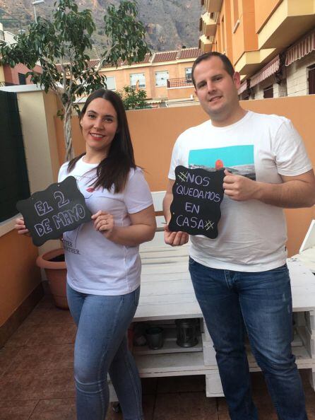 Lucía y Manuel en la terraza de casa mostrando su &#039;mensaje confinado&#039; a familiares y amigos