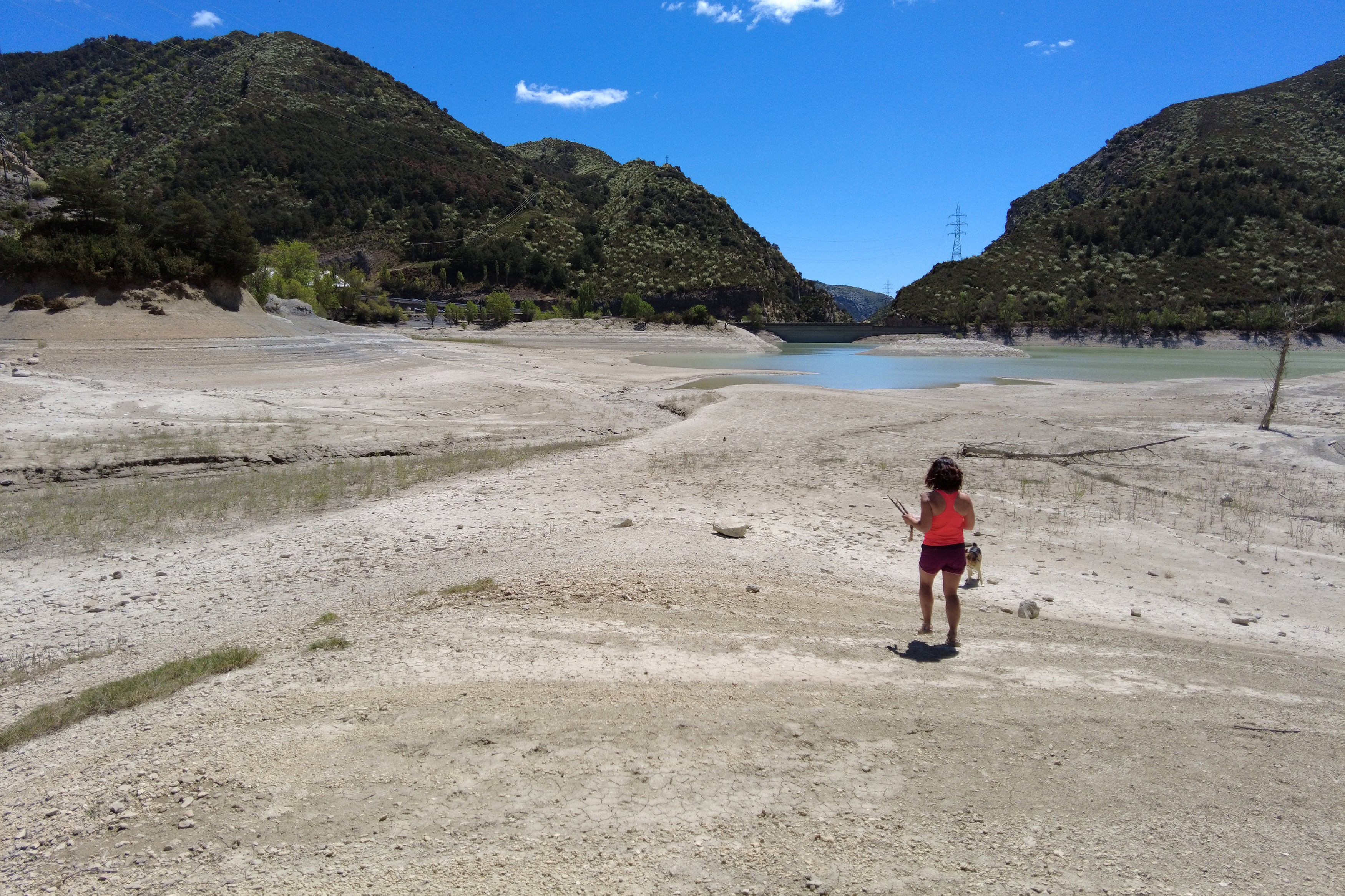 Una niña juega con su perro en el pantano de Arguis, situado a 20 kilómetros de la ciudad de Huesca