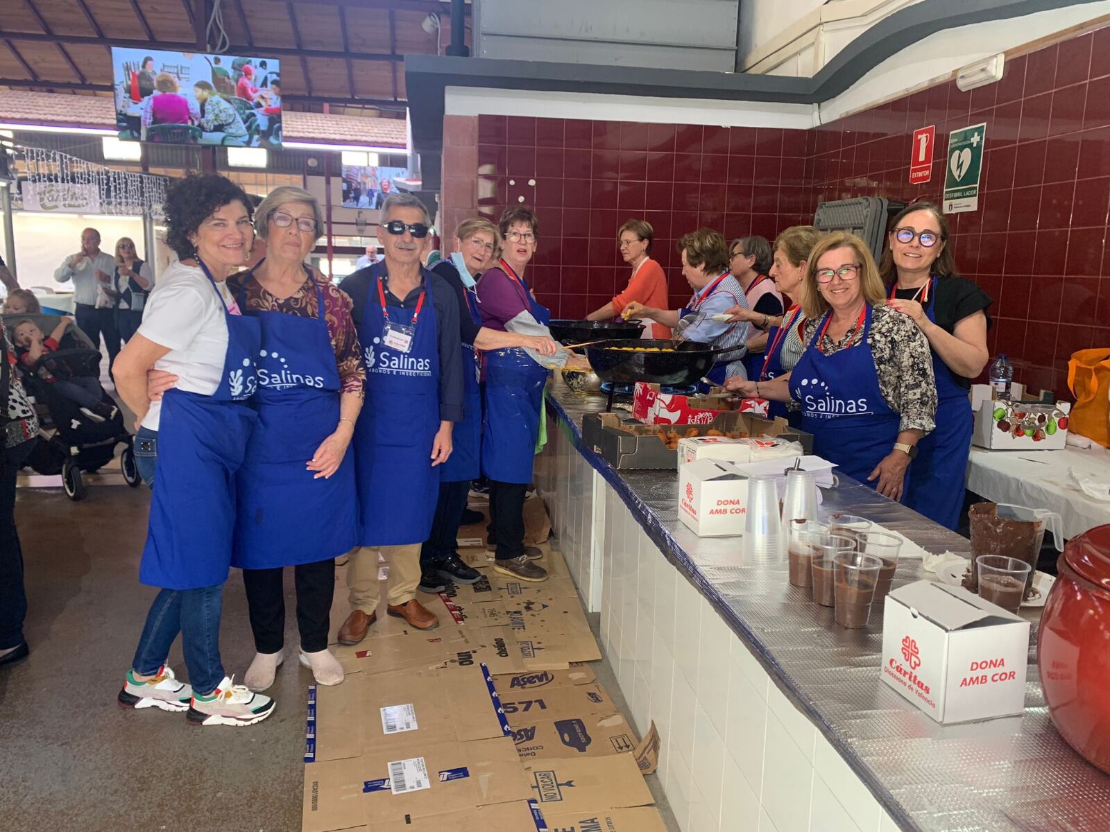 El presidente y voluntarios de Cáritas Tavernes preparando buñuelos y chocolate.