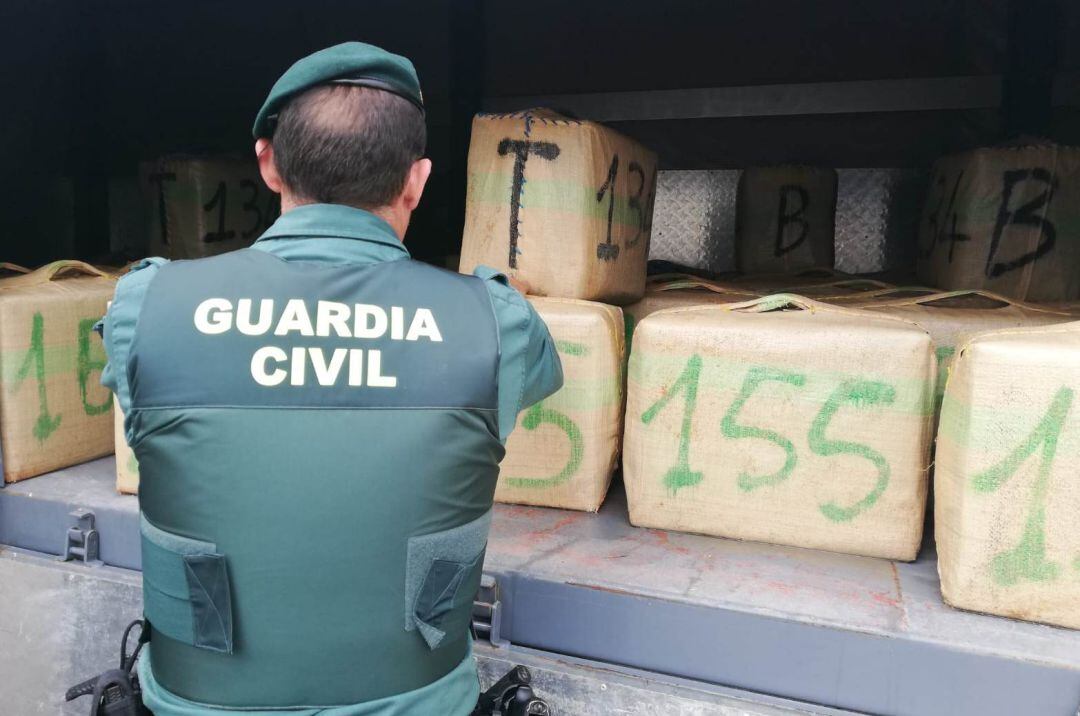 Un agente de la Guardia Civil con los fardos de hachís
