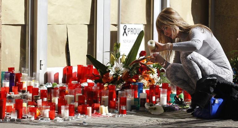 A woman lights a candle in memory of the teacher who yesterday resulted killed at the Joan Fuster Institute in Barcelona, on April 21, 2015. A 13-year-old boy armed with a crossbow and knife killed a teacher and wounded four others at his school in Barcelona on April 20, 2015 before being subdued, police and witnesses said. Among the injured were a Spanish language teacher and her daughter, also a student at the school, according to Spanish media reports.   AFP PHOTO / QUIQUE GARCIA