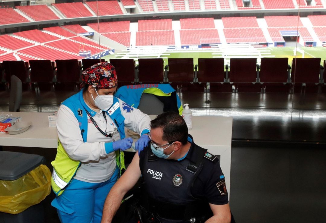 Un policía recibe la primera dosis durante el primer día de vacunación contra la covid-19 en el Wanda Metropolitano.